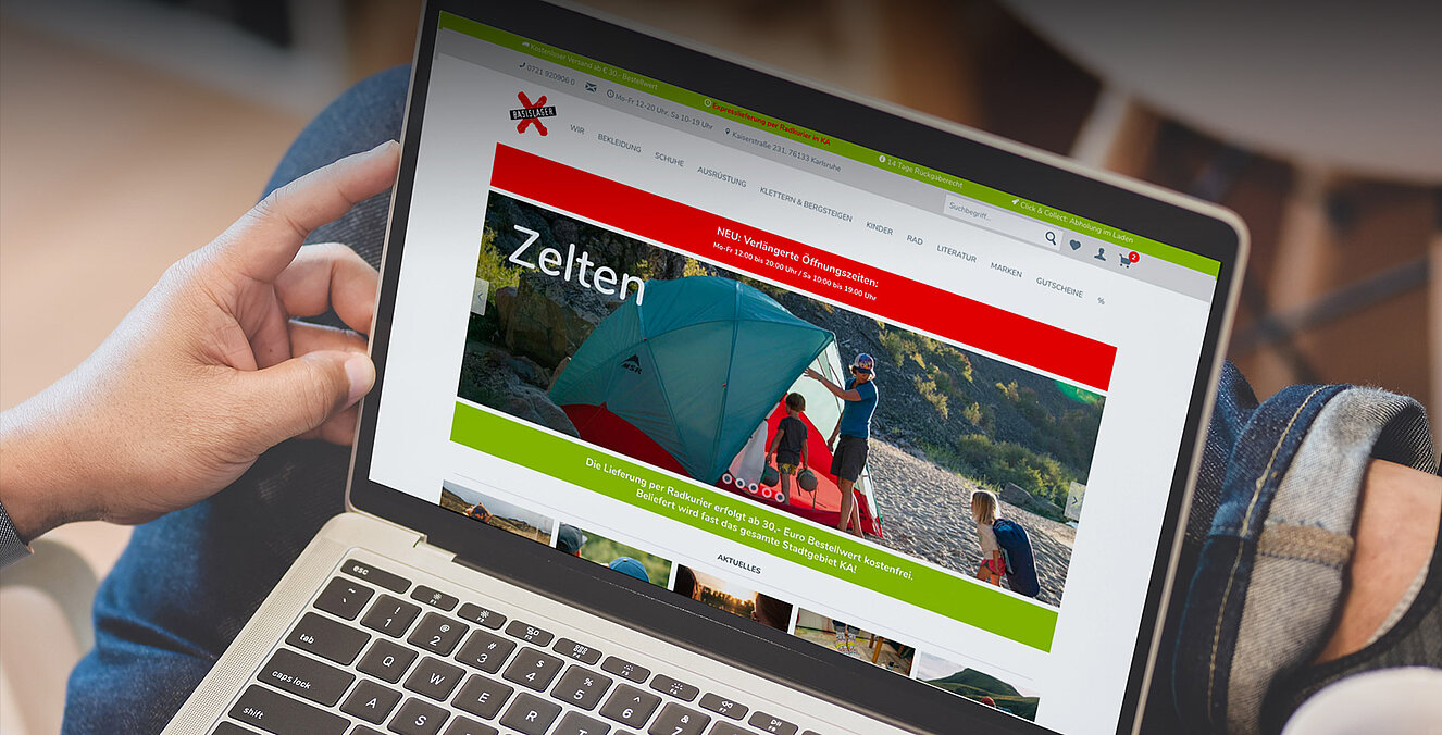 Mann surft mit Laptop im Onlineshop des Basislagers Karlsruhe